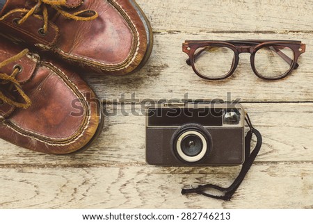Camera and glasses and Leather shoe on a wooden , Still life travel on wooden , look vintage