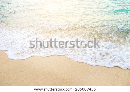 Wave of the sea on the sand beach with sunlight , for background