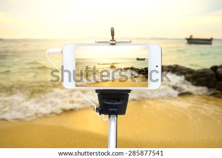 Travel concept - Mobile Phone photography at sea , with selfie Monopod ,Landscape Mobile phone