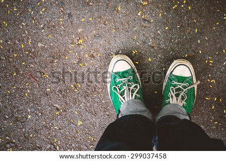 Green Sneakers shoes walking on concrete look top view , Canvas shoes on dirty road , Hister life