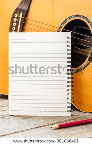 Notebook and pencil with guitar for writing music , Concept of music