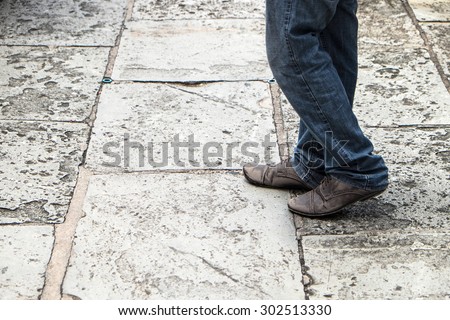 Walking on concrete : close-up view of man\'s leather shoes