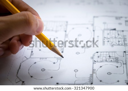 architect hand with pencil drawing blueprints