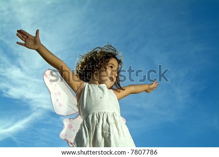 young girl with fairy wings flying against blue sky with cirrus clouds
