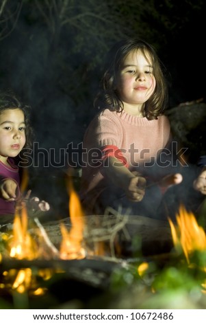 two girls having fun at a bonfire