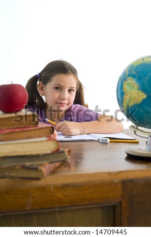 girl pupil sitting by the table with globe and red apple on a pile of books, Isolated on white