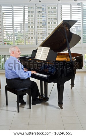 senior man playing on a grand piano at home