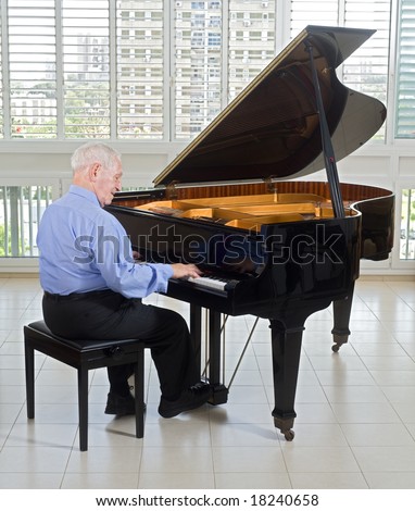 senior man playing on a grand piano at home