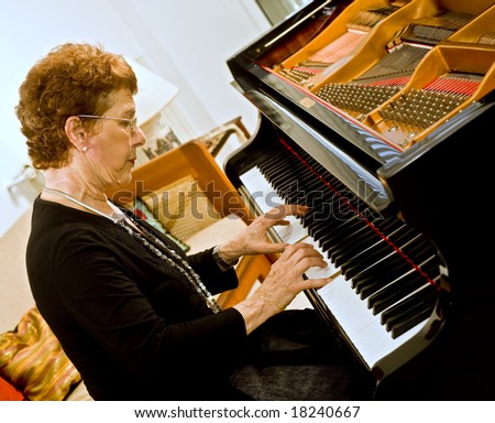 senior women pianist playing on a grand piano