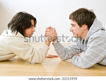 two brothers arm wrestling on the floor