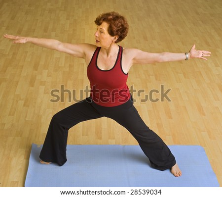 senior woman doing bikram hot  yoga in a gym