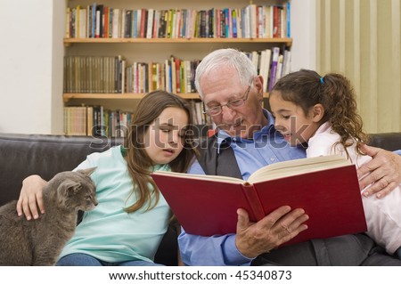 grandfather reading a story to his grandchild with a cat