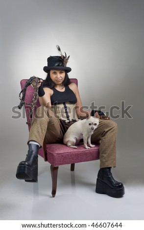 woman with corset breeches hat dog and whip on armchair