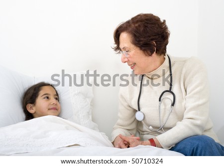 senior woman doctor visiting child penitent at home