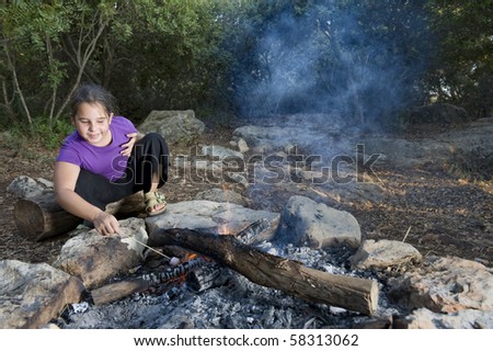 girl roasting a marshmallow in the campfire