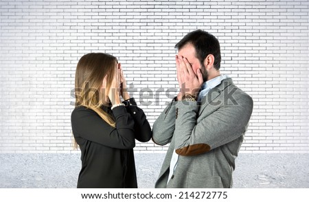 Couple covering their eyes over textured background