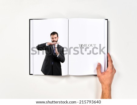 Young man doing the timeout sign printed on book