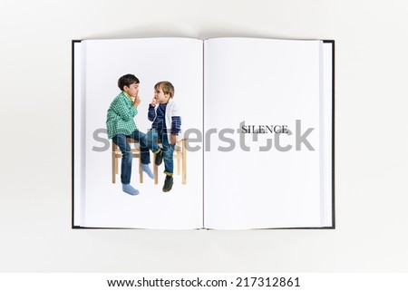 Kids doing silence gesture printed on book