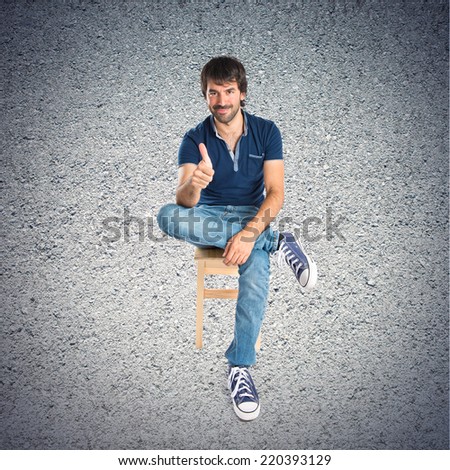 Man with thumb up over textured background