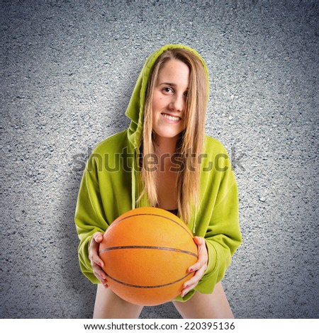 Young girl with basketball over textured background