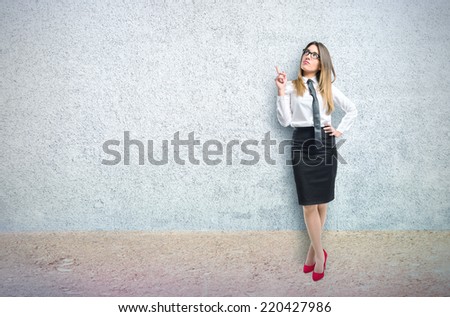 Cute businesswoman thinking an idea over textured background