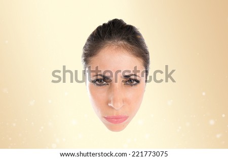 Face of angry woman over ocher background