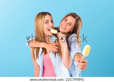 Friends eating ice cream over blue background
