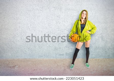 Girl with basketball over textured background