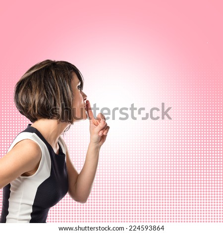 Pretty woman making silence gesture over isolated pink background