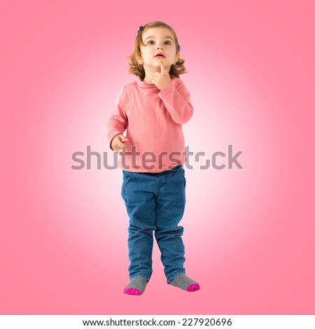 Little girl thinking over pink background