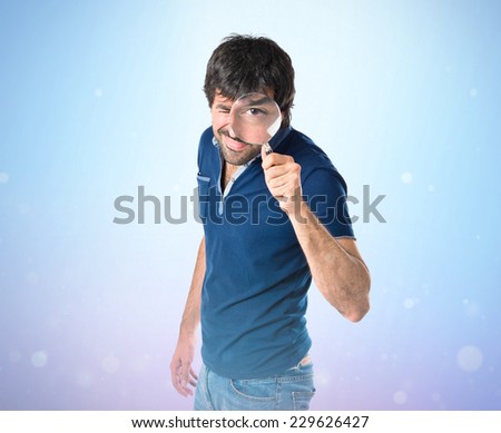 Man with magnifying glass over blue background
