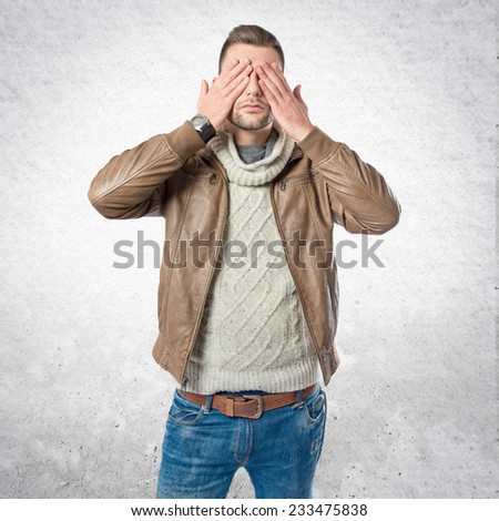 Men covering his eyes over textured background