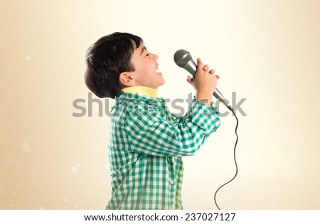Kid singing over ocher background