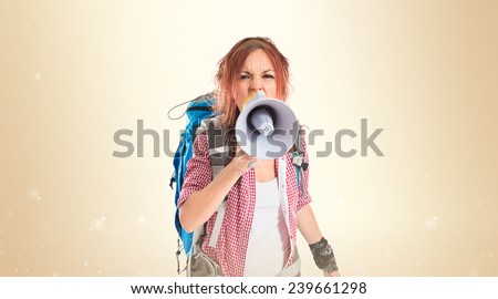 backpacker shouting by megaphone over ocher background