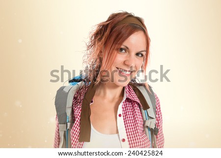 Pretty backpacker over isolated ocher background
