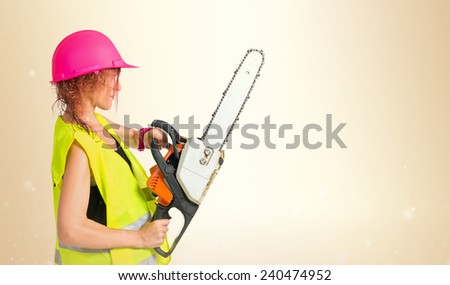 Worker woman with chainsaw over ocher background