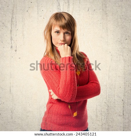 Cute young girl thinking an idea over textured background