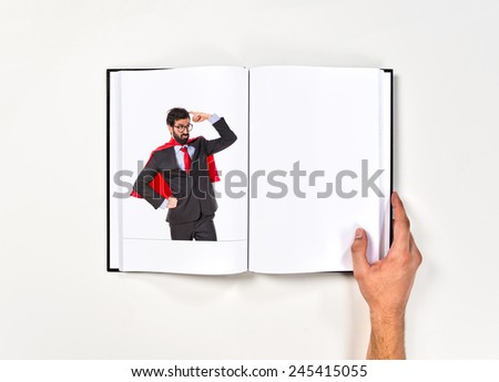 Businessman dressed like superhero thinking printed on book