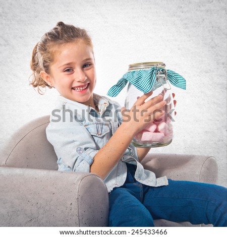 Blonde girl holding jar glass with sweetmeats inside