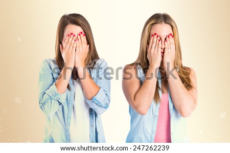 Girls covering her eyes over ocher background
