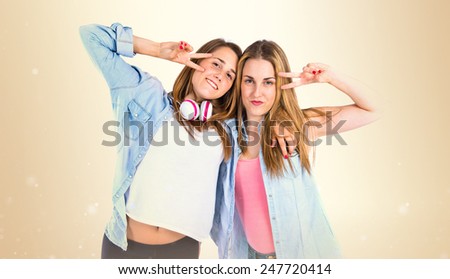 Friends doing victory gesture over ocher background