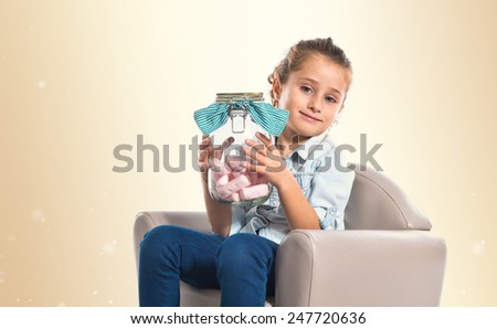 Blonde girl holding jar glass with sweetmeats inside