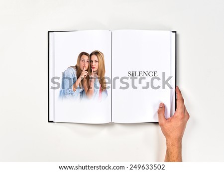 Friends making silence gesture printed on book