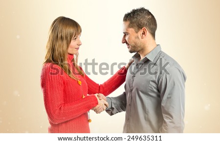 Couple making a deal over ocher background