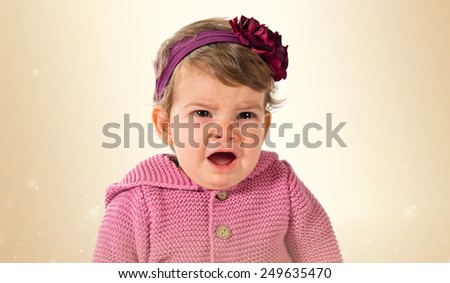 Girl crying over ocher background