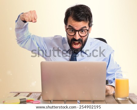 Businessman in his office giving punch over white background