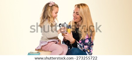 Mother and daughter playing with cup of coffee