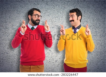 Twin brothers with fingers crossing
