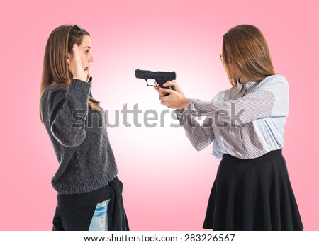 Teen girl pointing with a gun over colorful background
