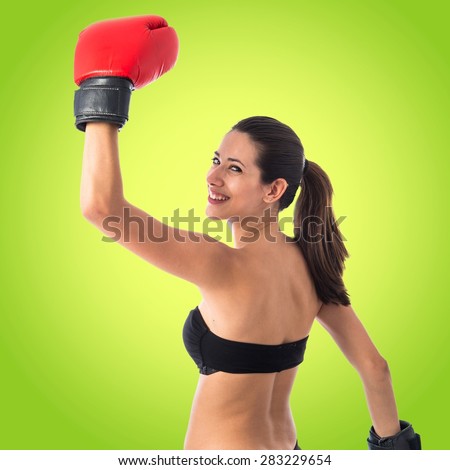 Happy sport woman with boxing gloves over colorful background